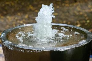 kleine Wasserfontäne an einem Brunnen foto