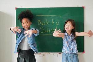 glückliche kleine Mädchen gegen Tafel mit zurück zur Schule foto