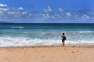 Mann am Strand mit Surfbrett foto