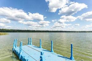 Farbiger Plastiksteg am Ufer eines großen Sees foto