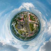 winziger Planet im Himmel mit Wolken mit Blick auf die Altstadt, Stadtentwicklung, historische Gebäude, Kreuzung mit Brücke über den breiten Fluss. Umwandlung eines sphärischen 360°-Panoramas in eine abstrakte Luftaufnahme. foto