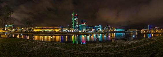 Nachtpanorama auf der Straße mit Blick auf Seereflexion und Wolkenkratzer foto