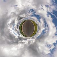 Winzige Planetentransformation des sphärischen Panoramas 360 Grad. sphärische abstrakte luftaufnahme auf der straße mit blauem himmel und fantastischen schönen wolken. Krümmung des Raumes. foto