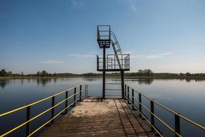 Silhouette des Sprungturms am See am Sommerabend foto