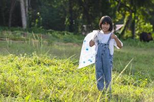 asiatische kinder packen freiwillig plastikflaschen in müllsäcke. Freiwilligenkonzept und Ökologie foto