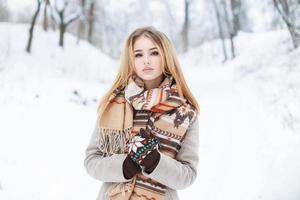 junges schönes Mädchen geht im Winterpark im Urlaub spazieren foto