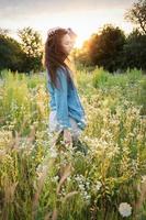 schönes Mädchen, das im Sommer mit Wildblumen auf dem Feld spazieren geht. foto