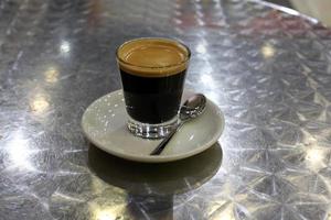 Heißer und starker Kaffee wird in eine Tasse gegossen. foto