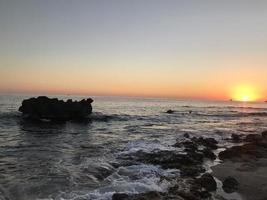 Sonnenuntergang Meer mit Klippe foto