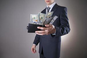 Geschäftsmann mit Geld im Studio auf grauem Hintergrund foto