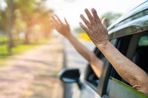 Fröhlicher Genuss und Freiheit bei der Reise mit erhobener Hand aus dem Fensterauto im Sommerurlaub foto