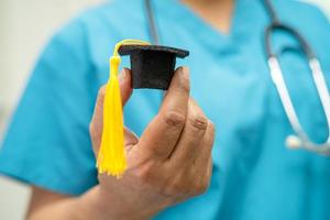 asiatische arztstudie lernen mit abschlusslückenhut in der krankenstation, kluges, geniales bildungsmedizinkonzept. foto