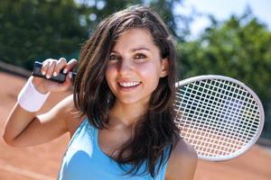 schönes junges Mädchen, das Tennis spielt