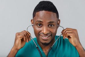 Afroamerikaner schwarzer Arzt auf grauem Hintergrund mit Stethoskop foto