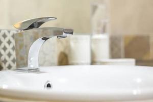Seifen- und Shampoospender am Wasserhahn Waschbecken mit Wasserhahn im teuren Loft-Badezimmer foto