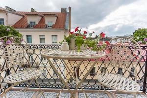 Blick vom Zimmer auf den Balkon mit Sommermöbeln und der Altstadt im Hintergrund foto