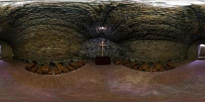 Vollständiges nahtloses 360-Grad-Winkelansichtspanorama in der unterirdischen Grotte in der Kirche mit einem Kruzifix auf einer alten Backsteinmauer in äquirechteckiger kugelförmiger Projektion. foto