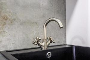 Stahlwasserhahn mit Wasserhahn in teurer Loft-Küche foto