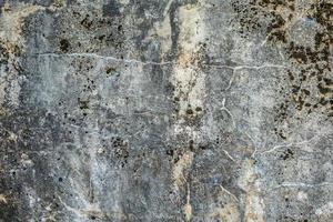 Oberfläche der betongrauen Wand einer Militärfestung in mit Moos bedeckten Rissen foto