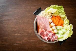 Sukiyaki oder Shabu Hot Pot schwarze Suppe mit rohem Fleisch und Gemüse foto