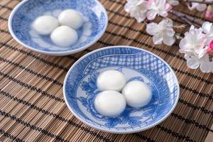 Nahaufnahme von Tangyuan Yuanxiao in einer Schüssel auf grauem Tisch, Essen für die Wintersonnenwende. foto