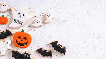 Draufsicht auf Halloween festlich dekorierte Puderzuckerplätzchen auf weißem Hintergrund. foto