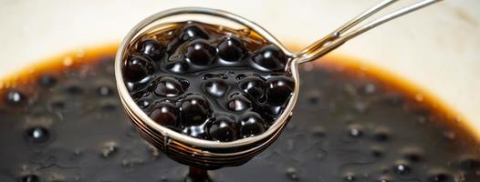 Kochen von mit braunem Zucker aromatisierten Tapioka-Perlenbällchen mit einer Schaufel. foto