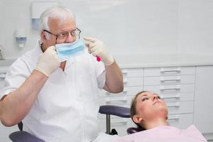 Zahnarzt setzt eine Schutzmaske foto