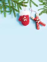 Weihnachtslayout Wintersport mit einem Fichtenzweig. Spielzeug Ski, Fäustlinge, blauer Hintergrund. neujahr, weihnachtsbaum, winterunterhaltung. rahmen. Platz kopieren foto