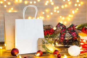 geschenkpaket aus papier für weihnachten und neujahr in festlicher dekoration und lichterketten. Tags mit Modell, natürliches Dekor, handgefertigt, Lieferung. Platz kopieren. Hintergrund foto