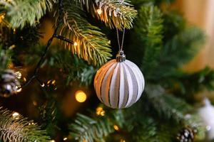 klassischer weihnachtlich geschmückter neujahrsbaum. weihnachtsbaum mit weißen und silbernen dekorationen, ornamenten spielzeug und ball. moderne Innenarchitekturwohnung im klassischen Stil. Heiligabend zu Hause. foto