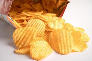 Kartoffelchips, leckeres Grillgewürz würzig für Crips, dünne Scheiben frittierter Snack Fast Food im offenen Beutel. foto