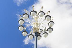 Moderne Straßenlaterne mit mehreren Glühbirnen gegen den blauen Himmel foto