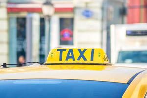 gelbes Taxischild. taxiauto auf der straße foto