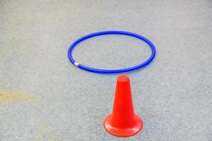Kunststoff blauer Reifen und roter Kegel auf Turnhalle, Nahaufnahme foto