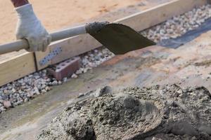 Arbeiter Mischen von Beton und Kies mit Spaten auf der Baustelle foto