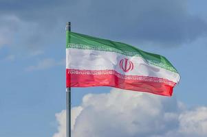 Die Nationalflagge des Iran weht über dem blauen Himmel foto