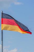 die nationalflagge von deutschland weht über dem blauen himmel foto