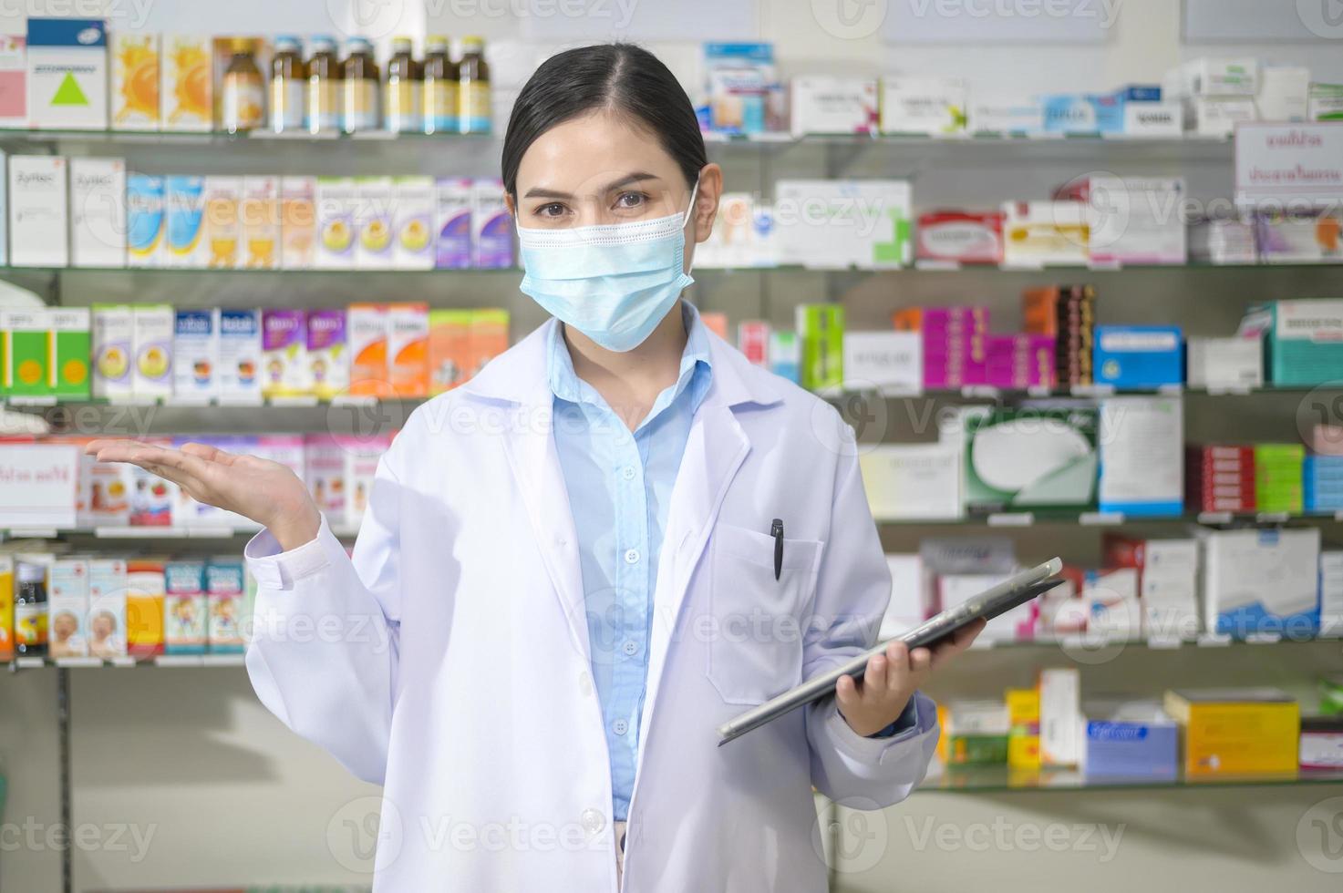 porträtt av kvinnlig apotekare bär ansiktsmask i ett modernt apotek apotek. foto