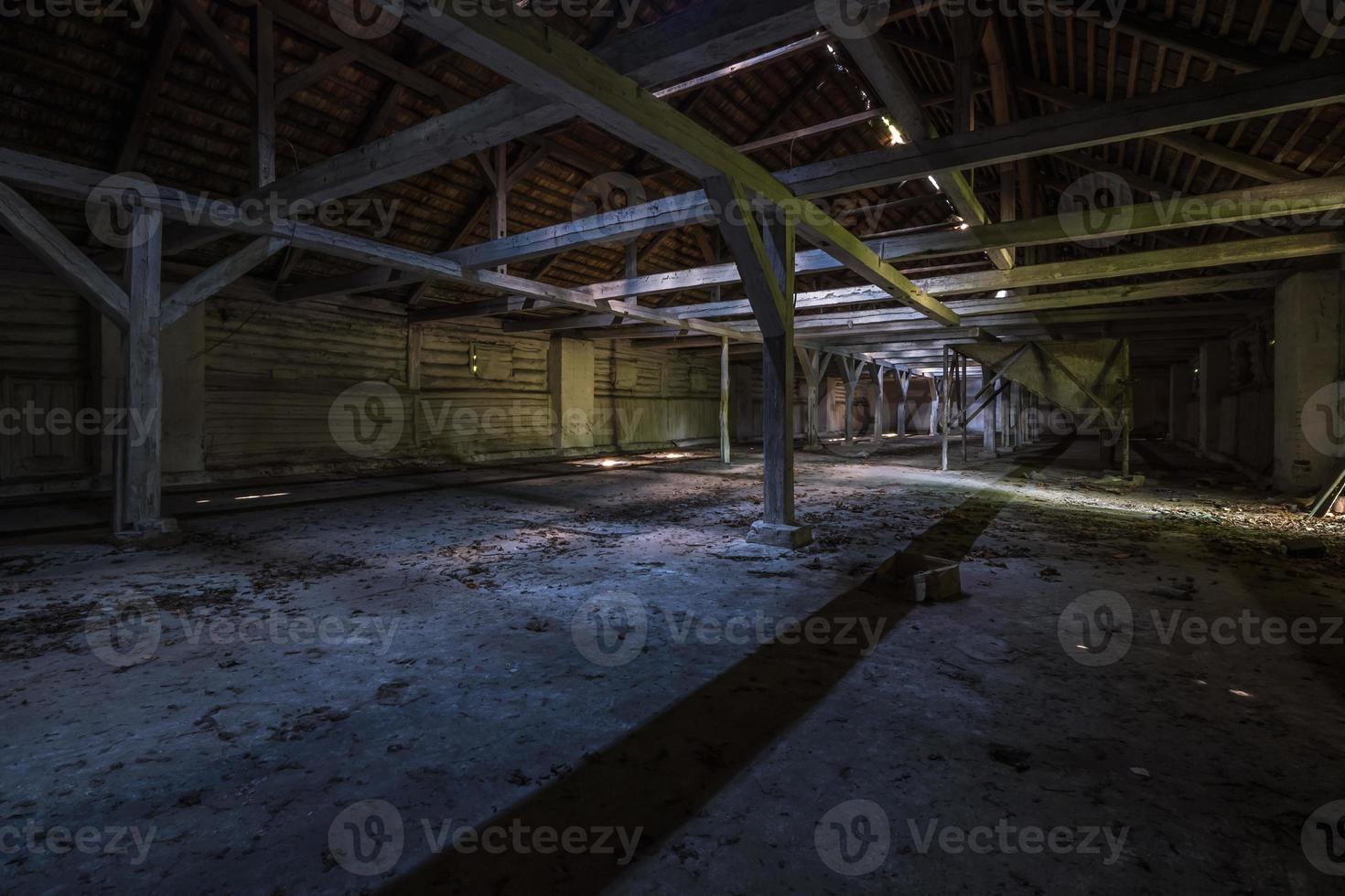 inuti mörk övergiven ruinerad trä förfallen hangar med ruttnande kolonner foto
