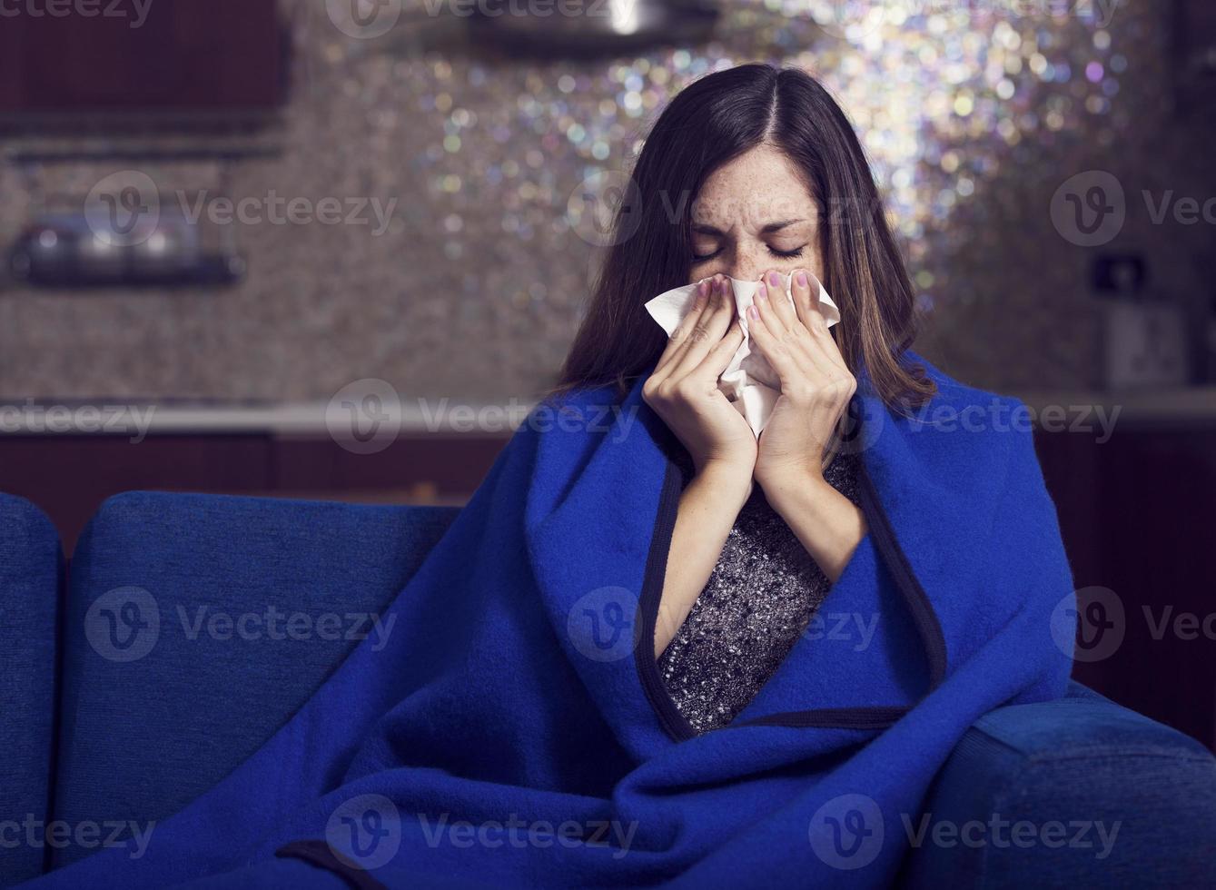 sjuk ung kvinna hostar och blåser foto