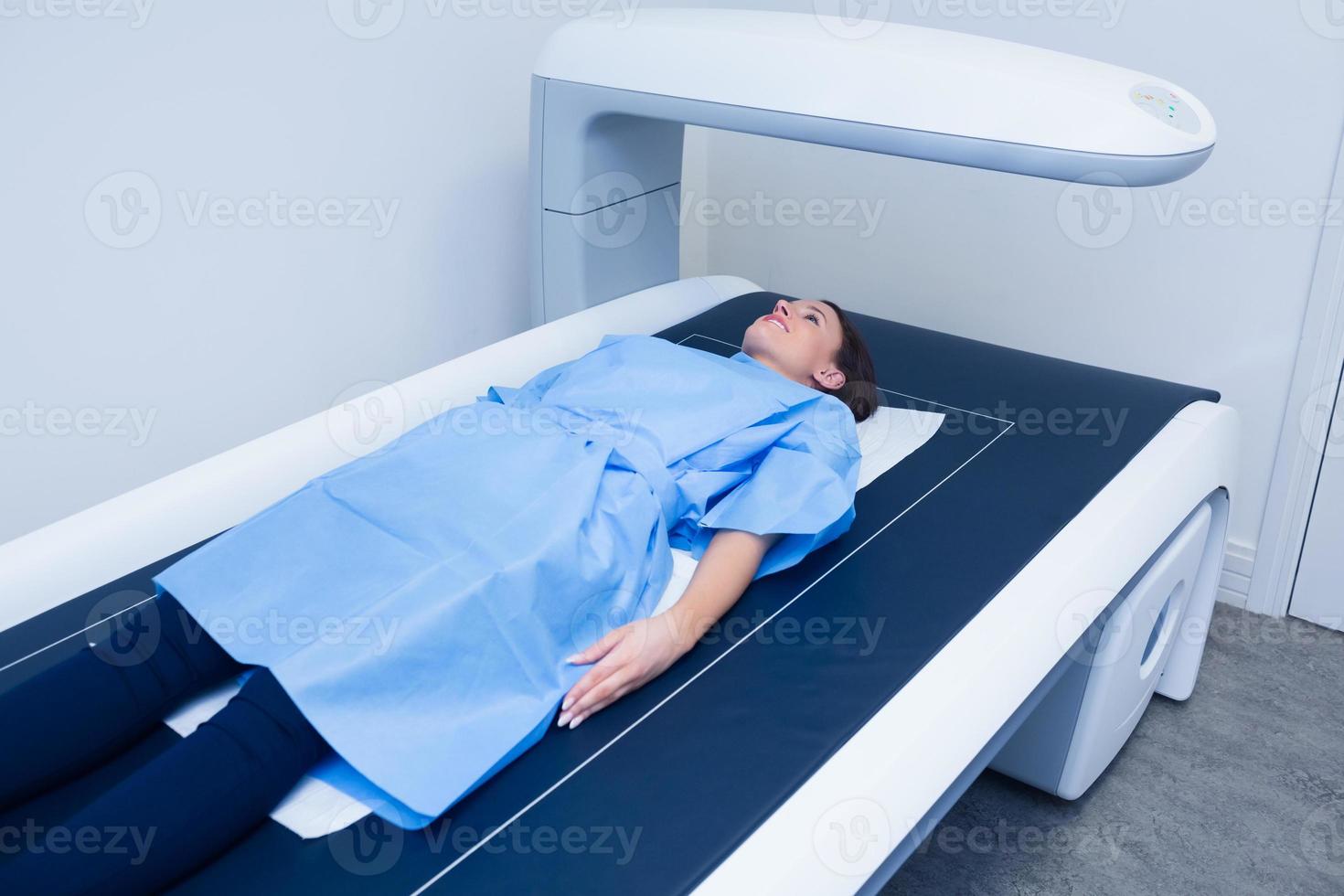 sjuk kvinna som ligger på en röntgenmaskin foto