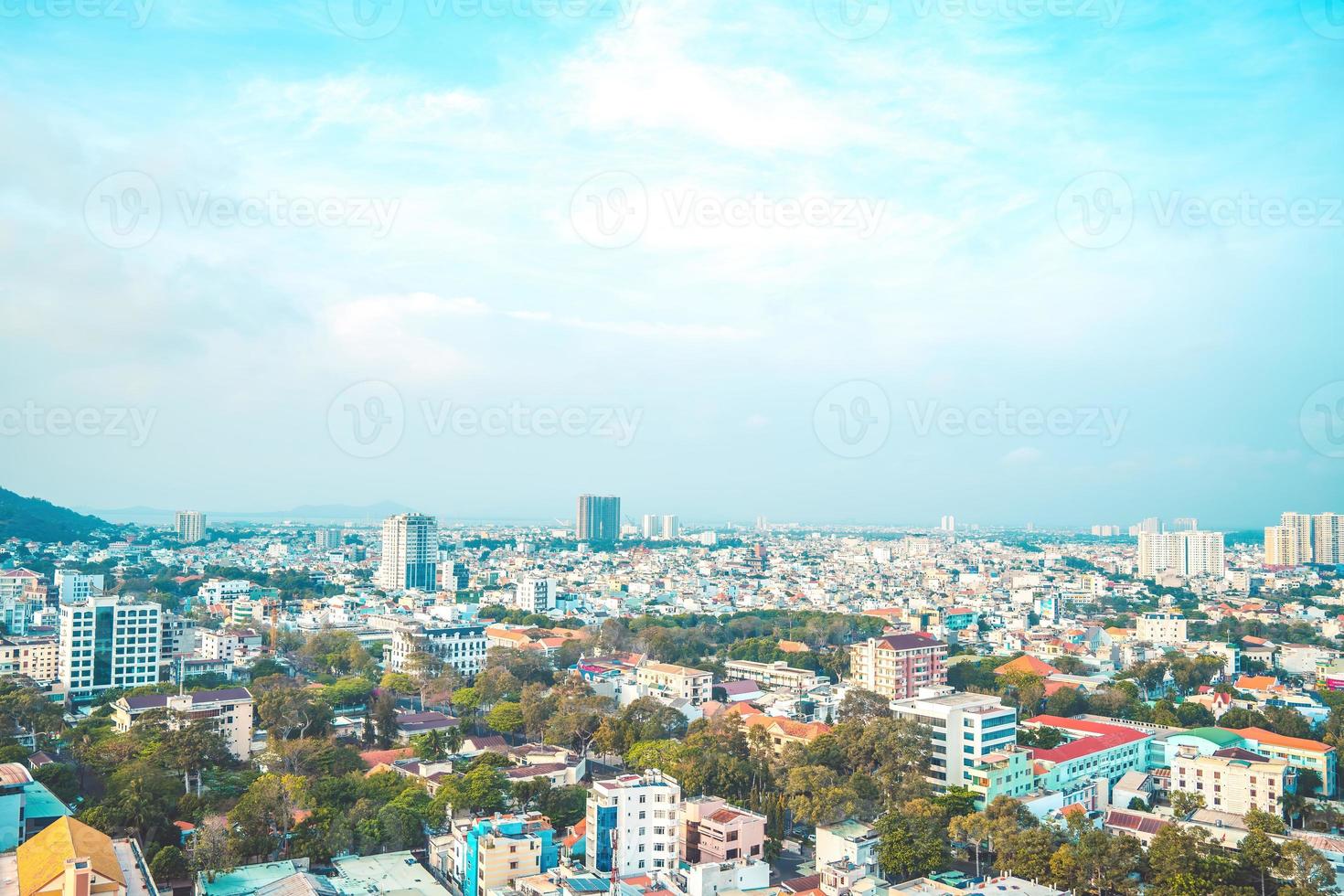 vung tau stadens flygfoto med vacker solnedgång och så många båtar. panoramautsikt över kustnära vung tau från ovan, med vågor, kustlinje, gator, kokospalmer och tao phung-berget i vietnam. foto