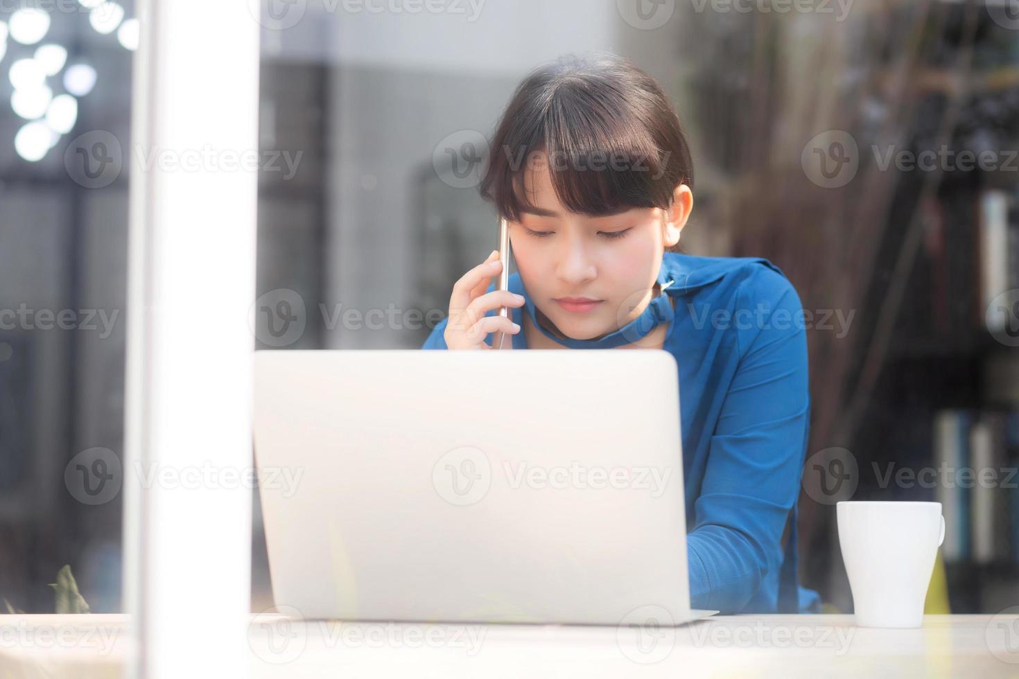 vacker asiatisk ung affärskvinna upphetsad och glad över framgång arbete med bärbar dator, flicka som tar mobiltelefon och arbetar kafé, karriär frilansande affärsidé. foto