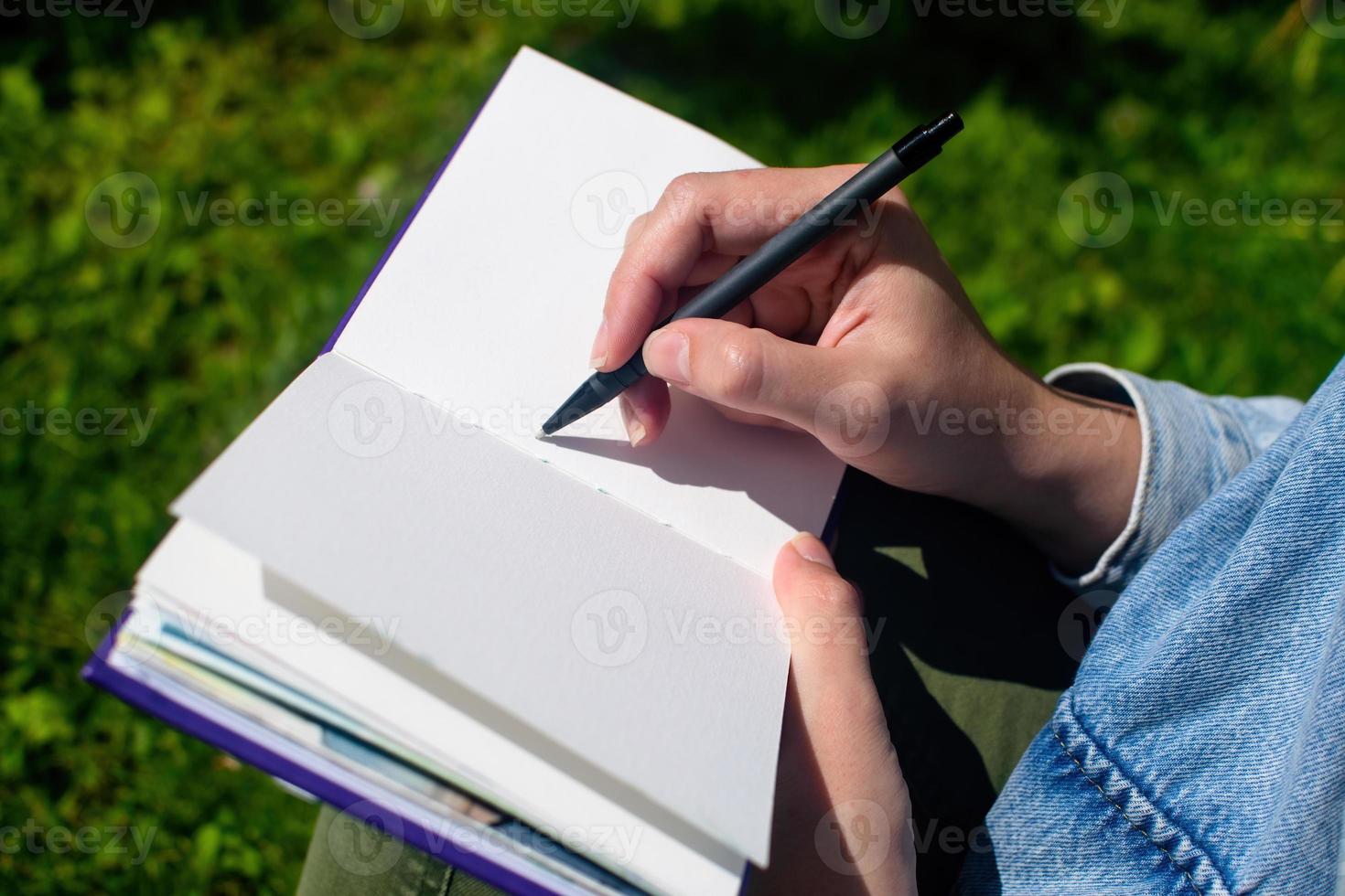 närbild av flickans händer skriver och ritar i skissbok och anteckningsblock. utbildning och studier, tid tillbaka till skolan. foto