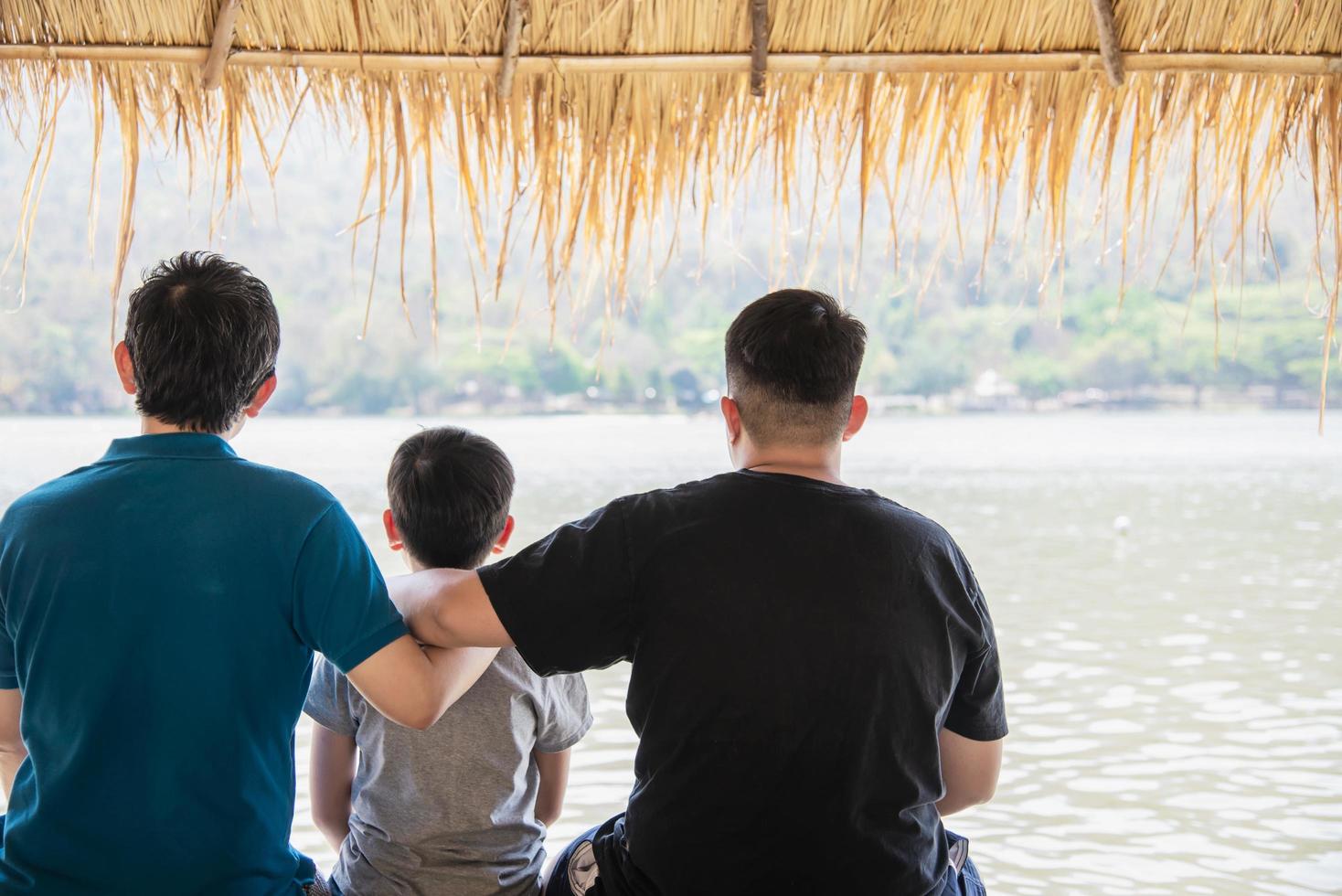 glad pappa och son under semester på vattenplatsen natur - lycklig familjesemester koncept foto