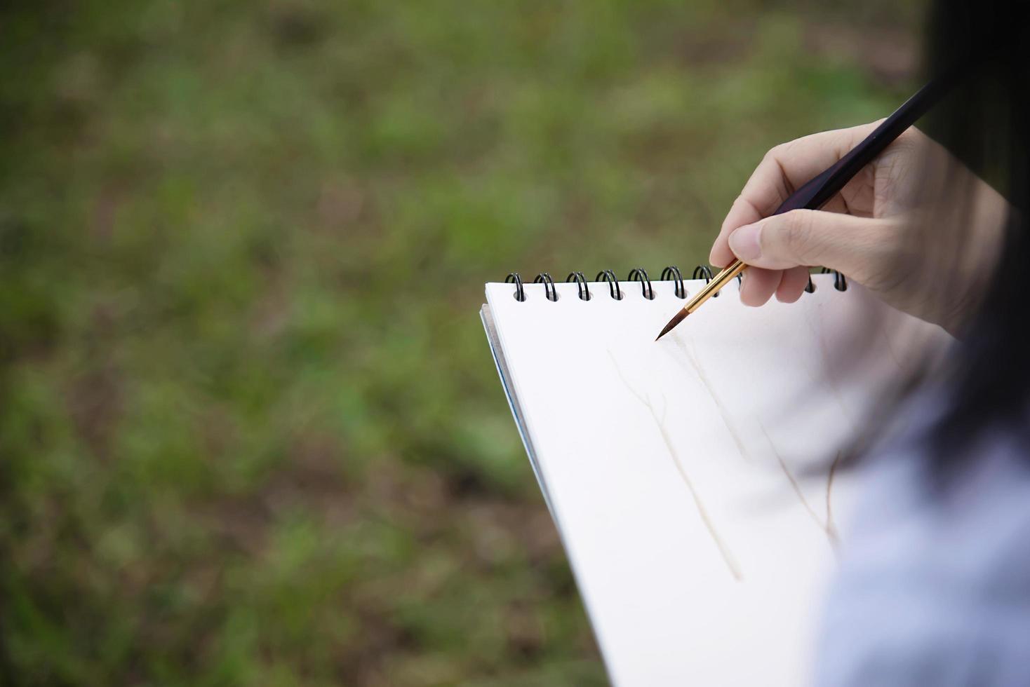 koppla av kvinna måla vattenfärg konstverk i grön trädgård skog natur - människor med kreativ konst i naturen stressreducering och meditationskoncept foto