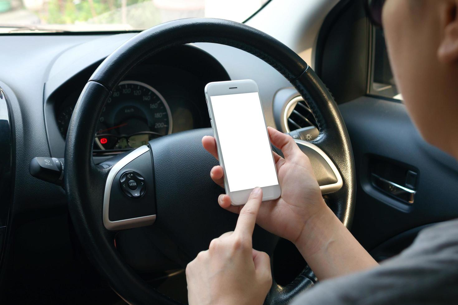 kvinnan håller tom skärm av smart-telefon i en bil foto