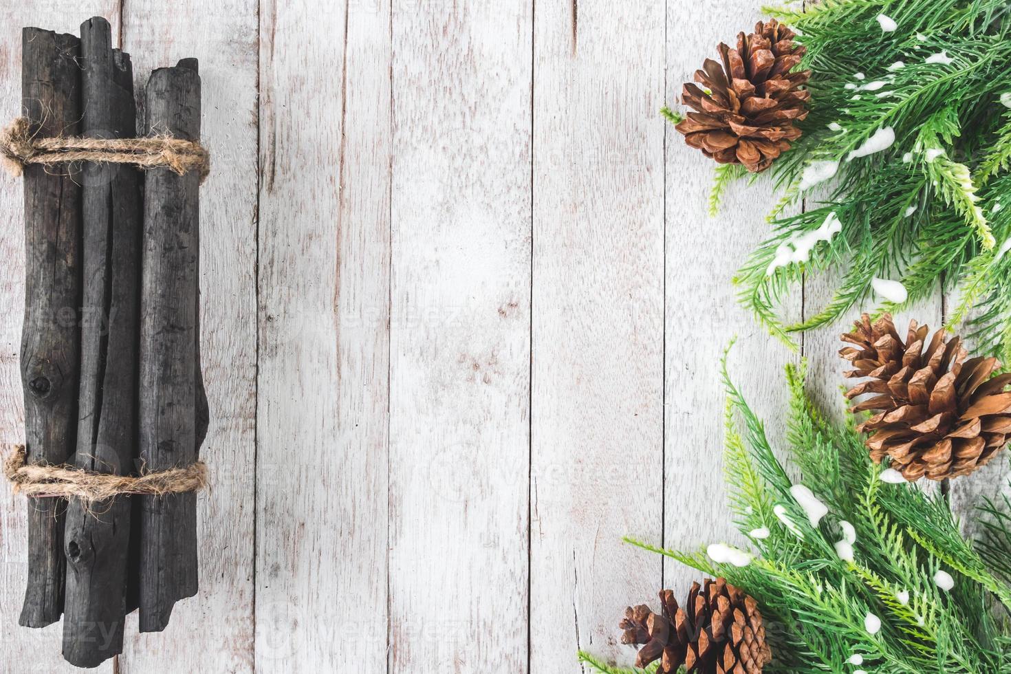 ovanifrån av gran med kottar och ved på träbord, juldekoration bakgrund foto
