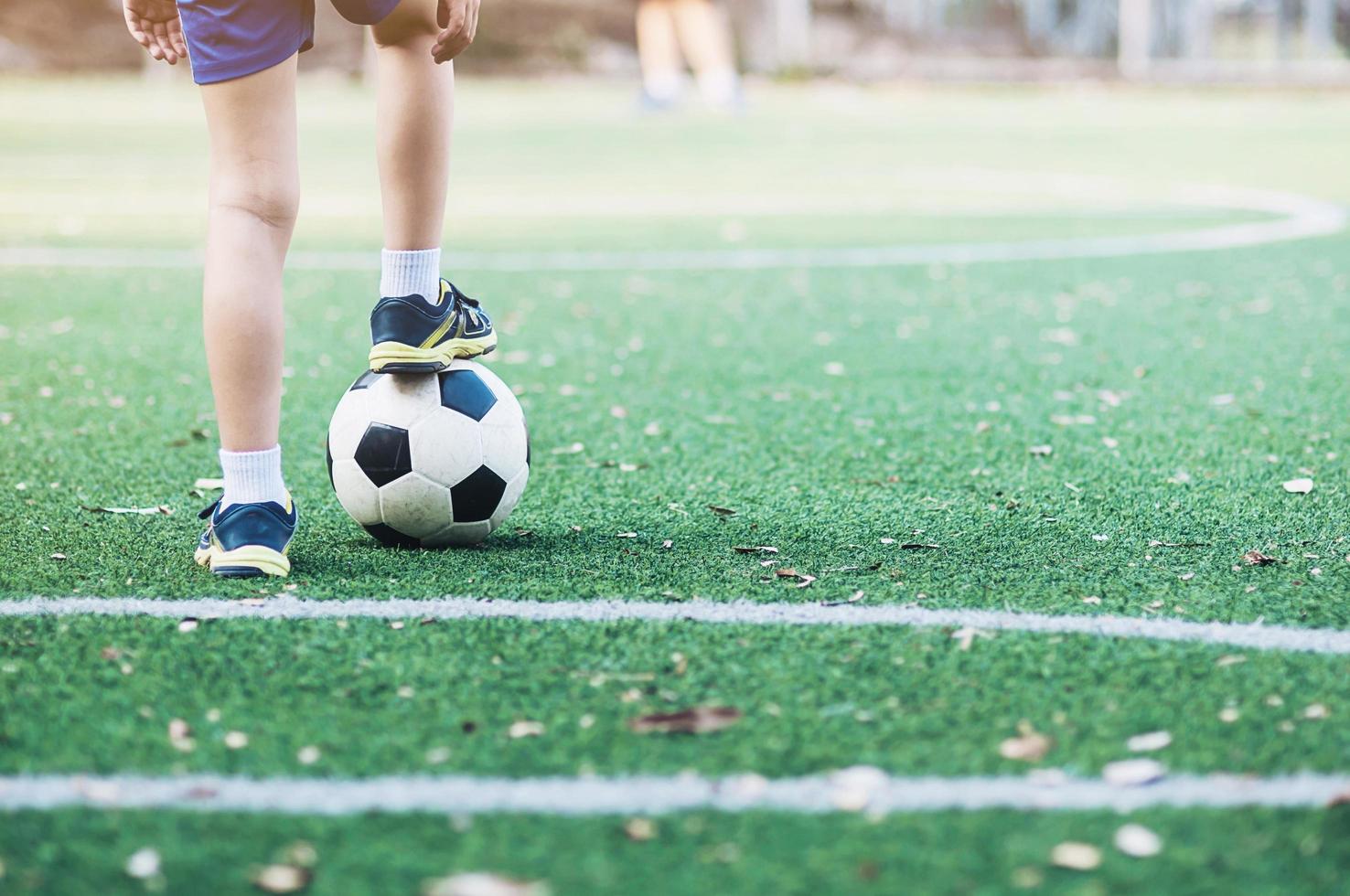 pojke står med boll på fotbollsplan redo att börja eller spela nytt spel - sport spelare koncept foto